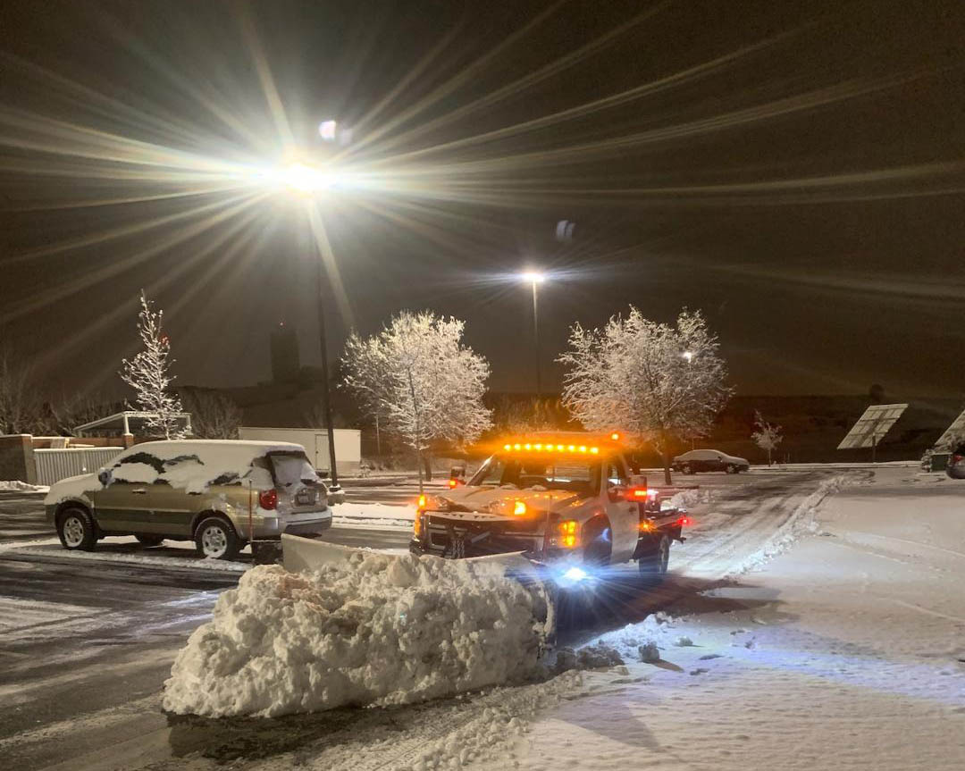 Snow plow pickup with pile of snow in front of blade.